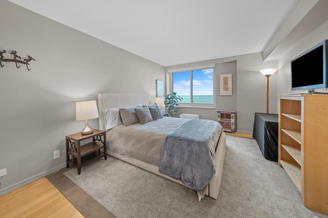 bedroom with light wood-type flooring and baseboards