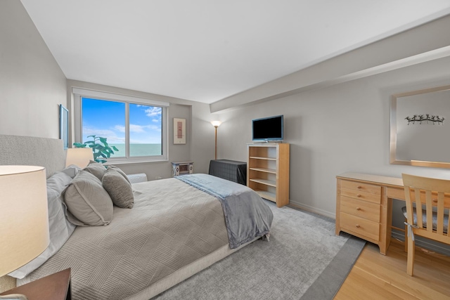 bedroom with light wood-type flooring and baseboards