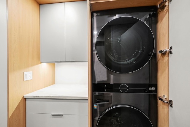 clothes washing area featuring laundry area and stacked washer / dryer