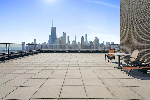 view of patio / terrace featuring fence and a city view