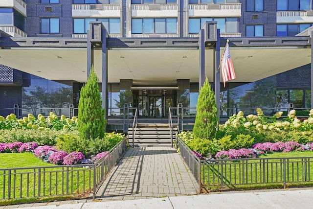 entrance to property featuring brick siding and fence