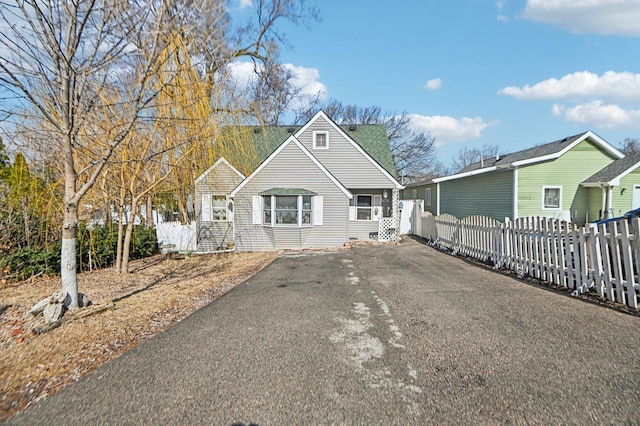 view of front of property with fence and roof with shingles