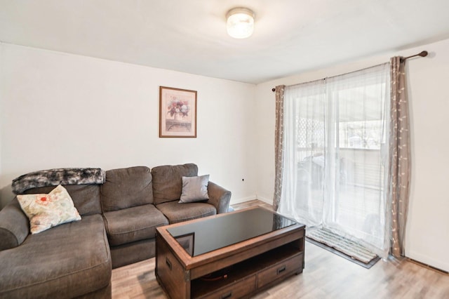 living area with baseboards and light wood finished floors