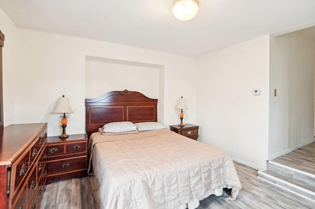 bedroom featuring baseboards and wood finished floors