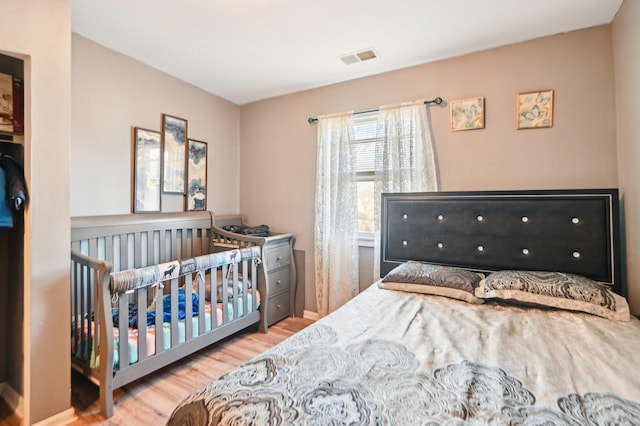 bedroom featuring wood finished floors and visible vents