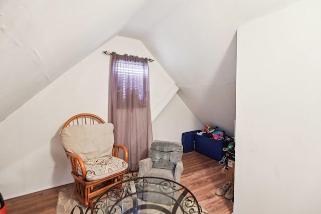 living area featuring vaulted ceiling and wood finished floors