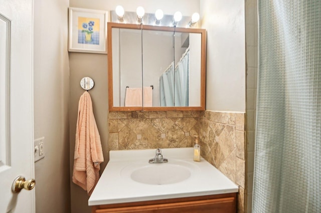 bathroom featuring a shower with shower curtain, backsplash, and vanity