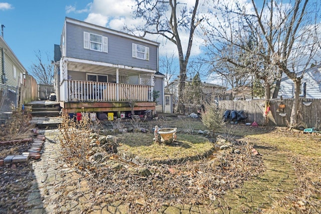 back of property with covered porch and fence