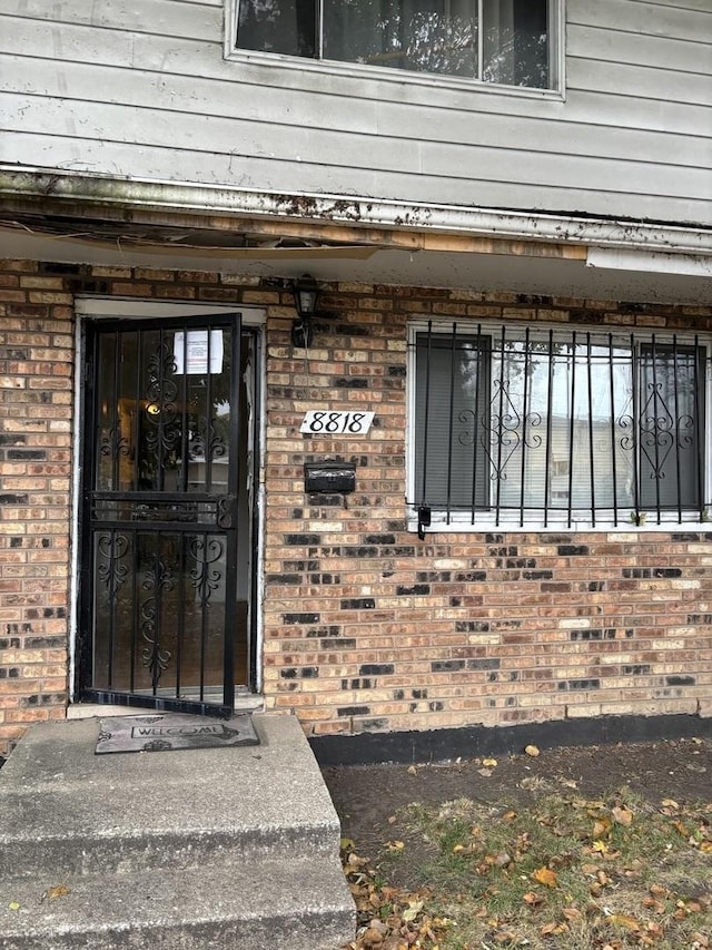 view of exterior entry featuring brick siding