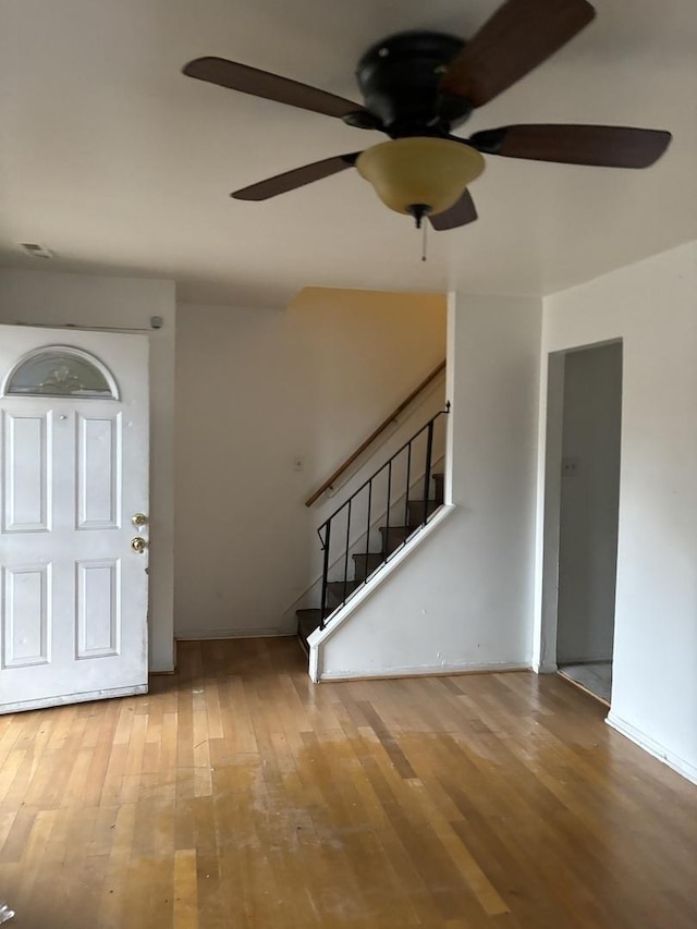 foyer entrance featuring light wood-style flooring, stairway, and ceiling fan