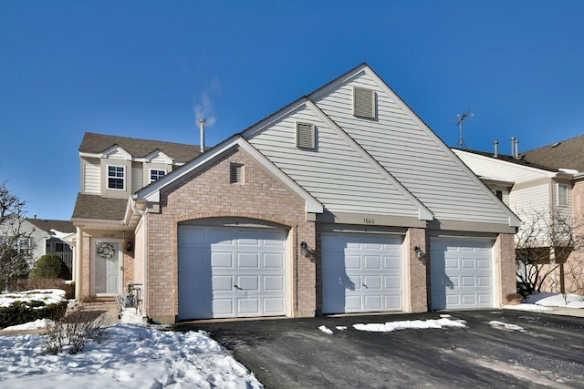 traditional-style home featuring a garage and brick siding