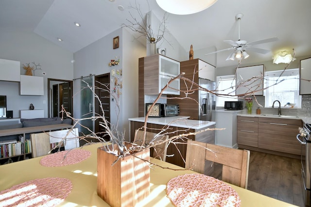 kitchen with modern cabinets, black microwave, light countertops, and wood finished floors