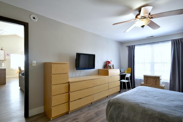 bedroom featuring baseboards, visible vents, ceiling fan, and dark wood-style flooring