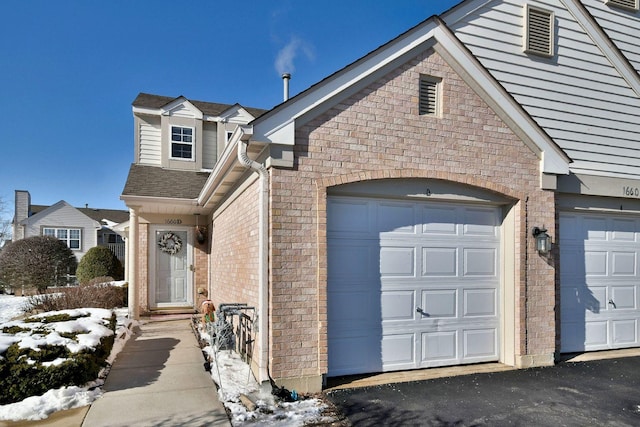 view of front of home with brick siding and roof with shingles