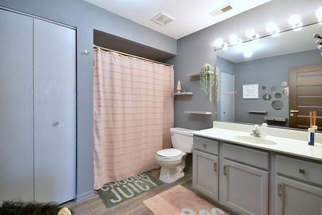 full bathroom featuring visible vents, vanity, toilet, and wood finished floors