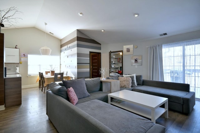 living area with vaulted ceiling, wood finished floors, and visible vents