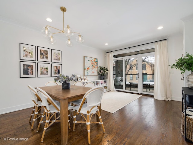 dining room featuring crown molding, recessed lighting, dark wood-type flooring, a chandelier, and baseboards