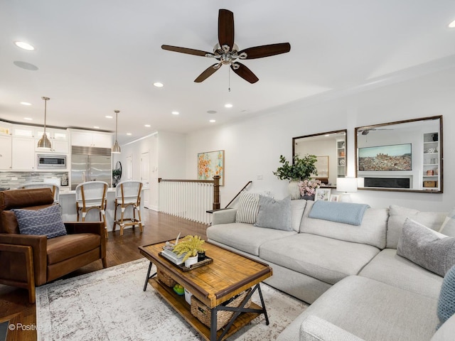 living area with wood finished floors, a ceiling fan, and recessed lighting