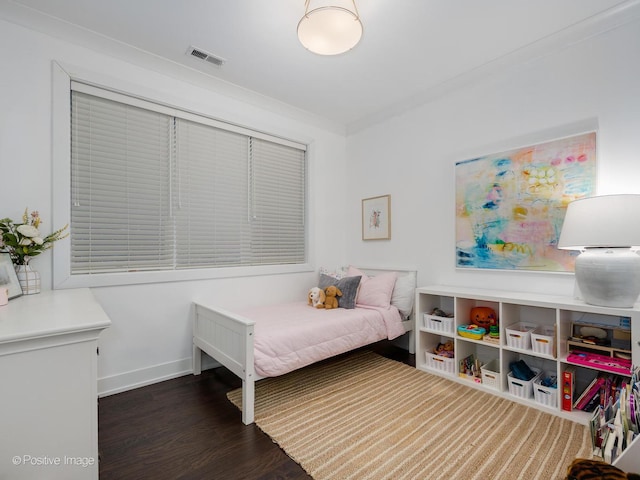 bedroom featuring crown molding, wood finished floors, visible vents, and baseboards