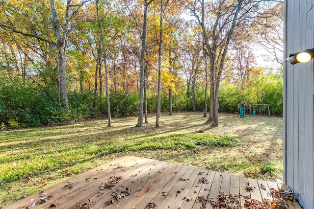 view of yard featuring playground community and a wooden deck