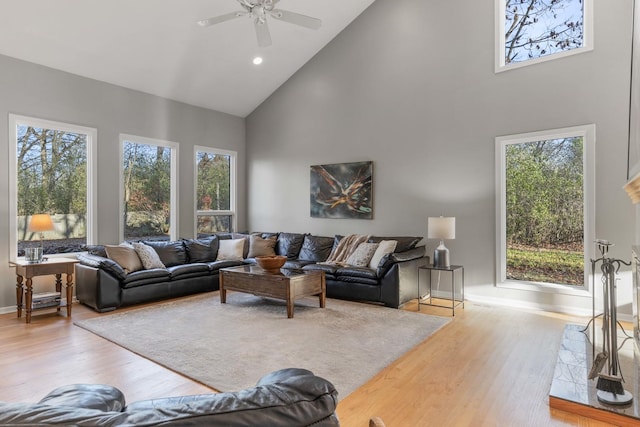 living room with ceiling fan, high vaulted ceiling, light wood-style flooring, recessed lighting, and baseboards