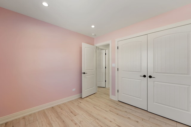 unfurnished bedroom with light wood finished floors, a closet, recessed lighting, and baseboards