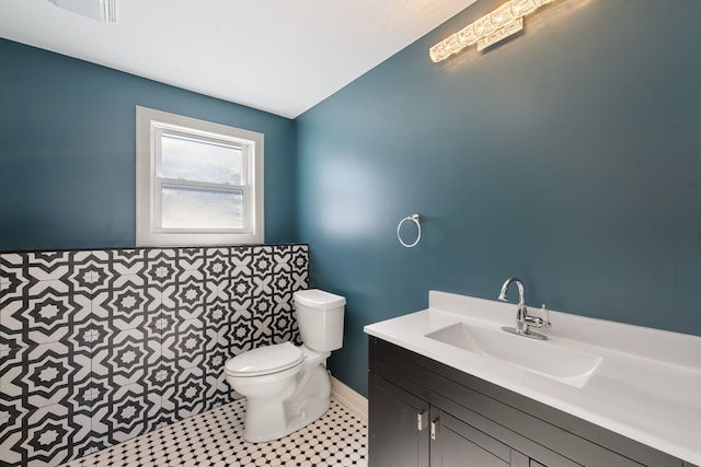 half bath featuring toilet, vaulted ceiling, and vanity