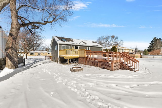 snow covered property with a fire pit and a wooden deck