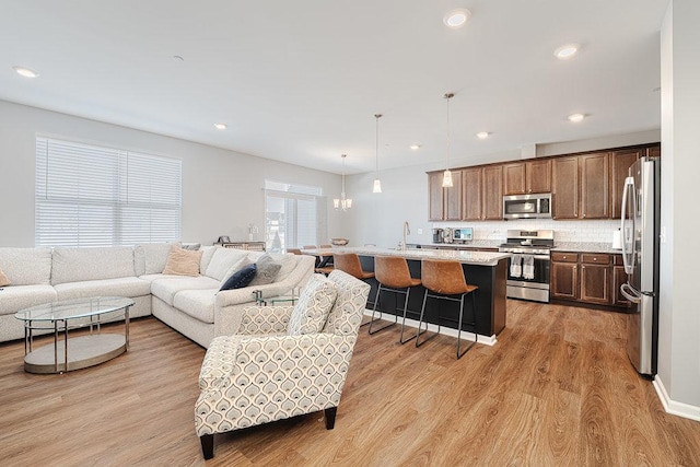 living room with light wood-type flooring and recessed lighting