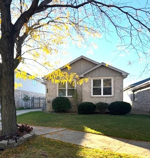 view of property exterior with brick siding, fence, a yard, driveway, and board and batten siding