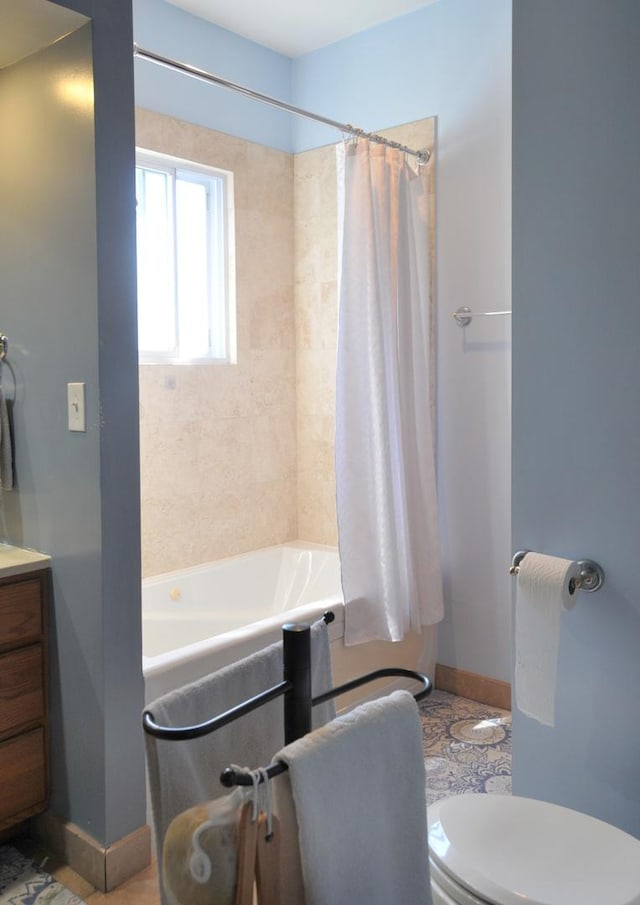 full bathroom with toilet, vanity, and baseboards