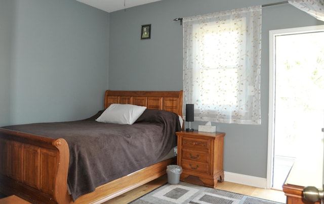 bedroom featuring light wood-style floors and baseboards