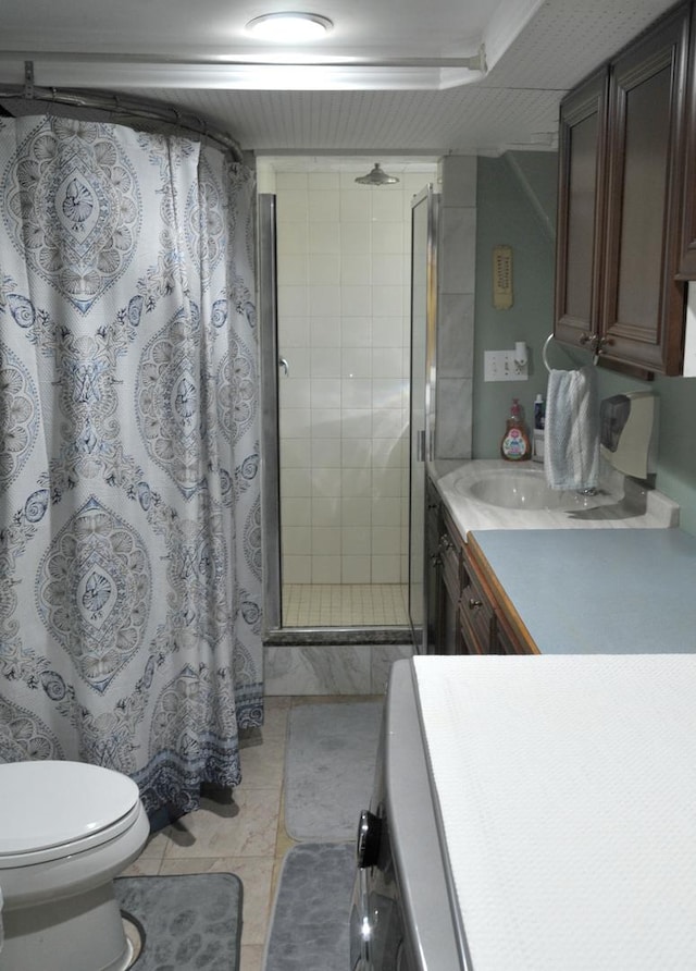 full bath featuring toilet, vanity, a shower stall, and tile patterned floors