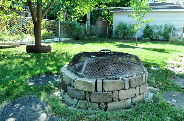 view of yard with an outdoor fire pit and fence