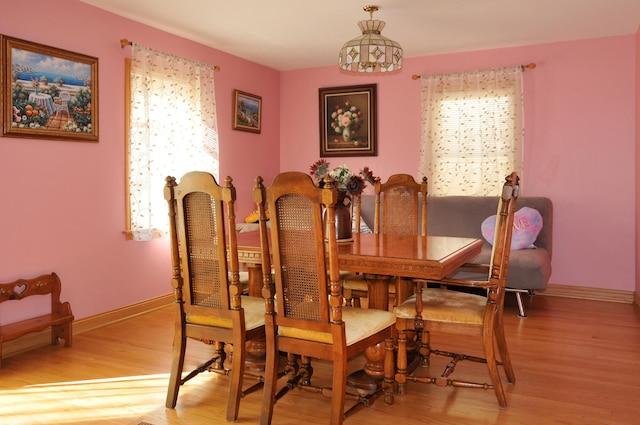 dining space featuring plenty of natural light, light wood-style flooring, and baseboards