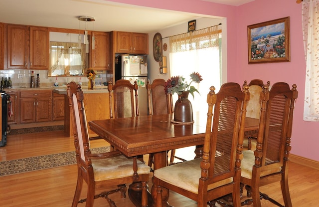 dining area with light wood-style flooring and baseboards