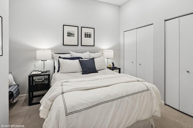 bedroom with carpet, two closets, and baseboards