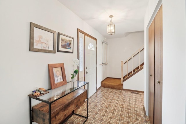 foyer entrance featuring baseboards and stairs