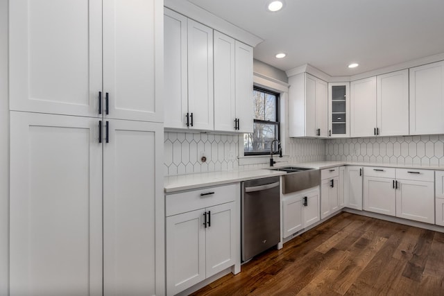 kitchen with glass insert cabinets, dark wood-style flooring, stainless steel dishwasher, white cabinetry, and a sink