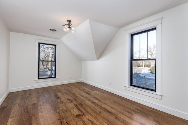 bonus room with baseboards, visible vents, lofted ceiling, wood finished floors, and a notable chandelier