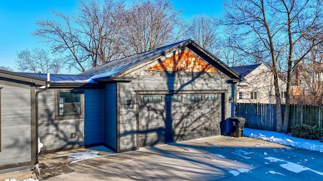 garage with fence and concrete driveway