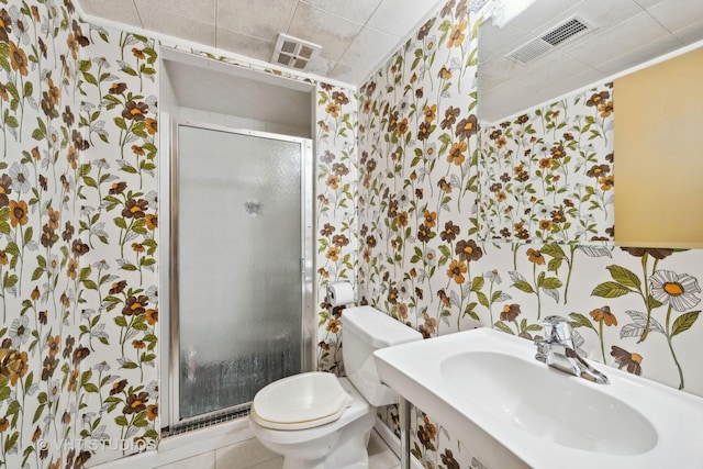 bathroom with visible vents, toilet, a stall shower, a sink, and wallpapered walls