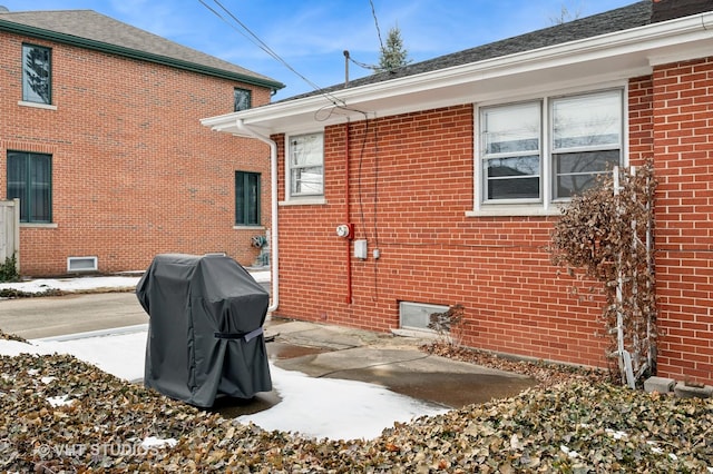 view of side of property featuring a patio and brick siding