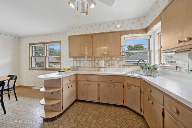 kitchen with a sink, light countertops, a wealth of natural light, open shelves, and wallpapered walls