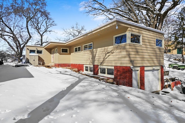 view of snowy exterior with an attached garage