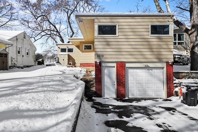 exterior space featuring a garage and brick siding