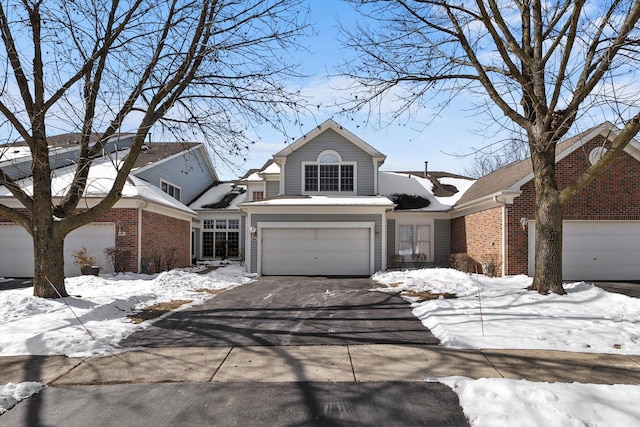 traditional home with driveway, a garage, and brick siding