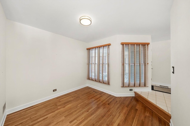 spare room with wood finished floors and baseboards