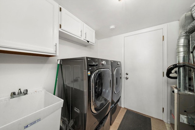 laundry area with cabinet space, a sink, washing machine and clothes dryer, and light tile patterned flooring