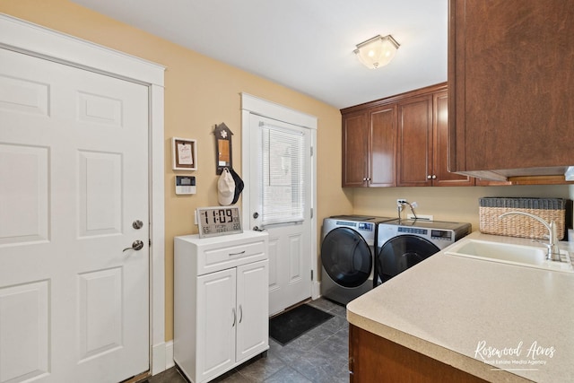 clothes washing area with cabinet space, washer and clothes dryer, and a sink